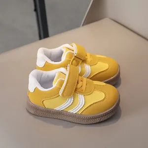 Detailed top view of kids sneakers featuring yellow leather and non-slip rubber soles