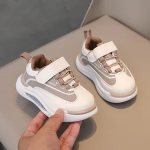 Dettaglio di scarpe sportive per bambini con chiusura a strappo e pelle beige