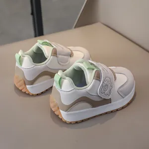 Close-up of kids' sneakers featuring velcro straps and cute cartoon dinosaur patterns