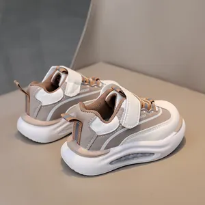 Dettaglio di sneakers in pelle per bambini con inserti beige e chiusura a strappo