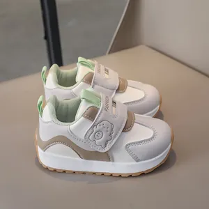 Detail of children's warm sneakers showing Velcro straps with cute dinosaur and fashion text