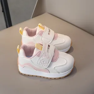 Detail of children white sneakers featuring cartoon rabbit decor and double velcro straps