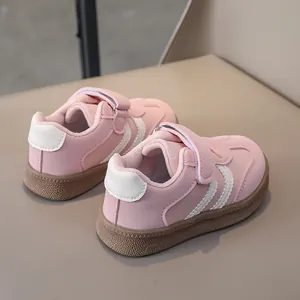 Detail of pink leather kids sneaker featuring magic tape closure and brown rubber sole