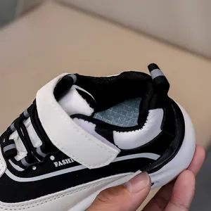 Dettaglio delle scarpe sportive per bambini con velcro e design a contrasto bianco e nero