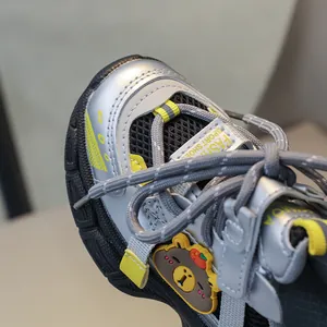Detailed view of kids sneaker featuring mesh texture and 3D cartoon bear ornament
