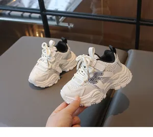 Détail de chaussures papa enfants en maille blanche avec empiècements cuir et velcro