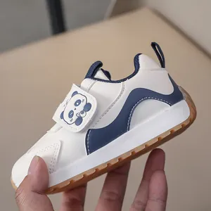 Close-up of kids' white sneaker with panda velcro strap and durable rubber sole