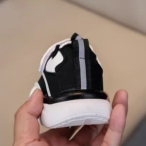 Dettaglio di sneaker per bambini con design del tallone bianco e nero, tirante e suola in gomma
