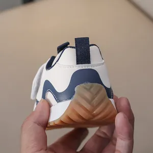 Detail of blue and white kids' sneakers showing non-slip rubber sole and heel tab