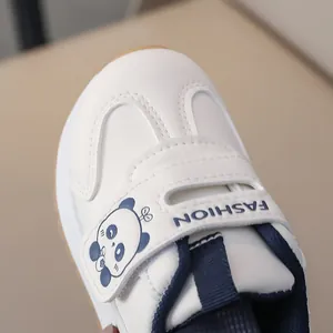 Detail of kids white sneaker with velcro strap featuring a cute panda and FASHION text