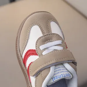 Detail of kids' retro sports shoe with beige suede, red stripes and velcro strap