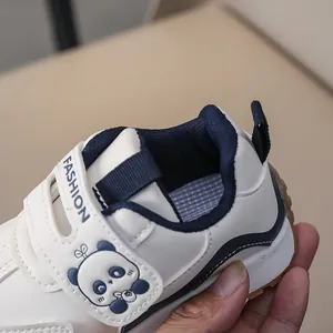 Detail of toddler white sneakers with cartoon panda and velcro strap closure