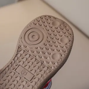 Close-up of non-slip rubber sole with texture and size 23 mark on boys sneakers