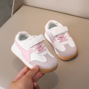 Close-up of pink and white kids trainer shoes with velcro strap and gum sole