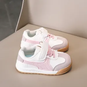 Detail of pink and grey kids' sneakers with hook-and-loop straps and rubber sole