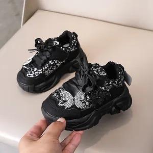 Détail de baskets noires pour filles avec paillettes argentées et nœud papillon