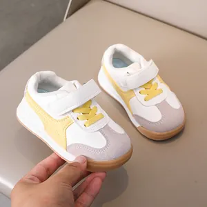 Detailed close-up of kids' retro trainer shoes with yellow stripes and gum rubber sole