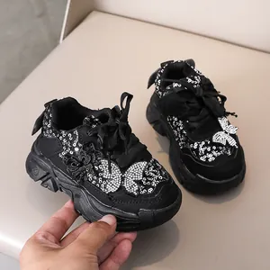 Gros plan de baskets noires pour filles avec paillettes argentées et nœud brillant
