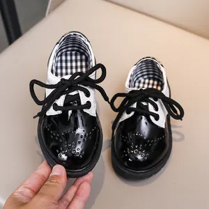 Chaussures richelieu enfant en cuir verni noir et blanc avec lacets et détails fleuris