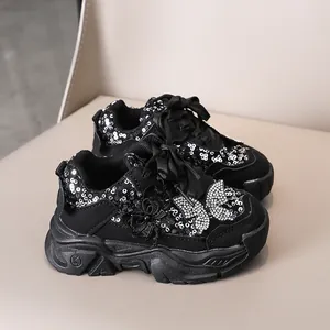 Gros plan sur les baskets noires pour filles avec paillettes et détails papillons 3D