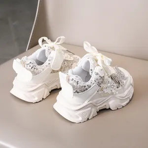 Détail de baskets filles avec fleurs en perles, paillettes et lacets en ruban de soie