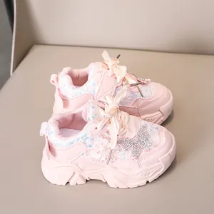 Détail de baskets roses pour fillettes avec paillettes, fleurs 3D et lacets en ruban satin