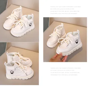 Detail view of beige kids ankle boots with side zipper and decorative metal buckle