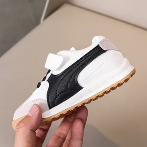 Detail of children low-top sneaker featuring white faux leather and grey suede textures