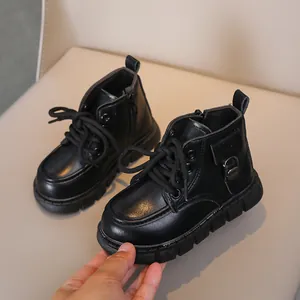 Detailed close-up of non-slip rubber soles on children's black leather boots