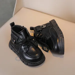 Close-up of black leather kids boots with laces and metal side zip on a soft surface