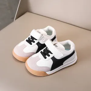 Kids low-top sneakers in white and black with velcro straps and non-slip gum soles