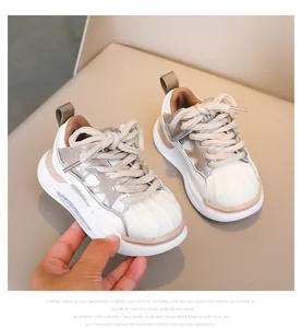 Close-up of kids casual sneakers with rubber shell toe and soft beige leather finish
