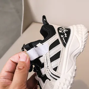 Détail de la basket pour enfant montrant la bande velcro, le logo et la maille respirante