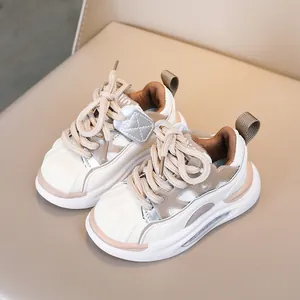 Detailed close-up of kids' beige patch sneakers with shell-toe and thick rubber soles