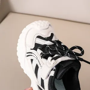 Détail d'une chaussure de sport enfant en maille respirante avec bande décorative