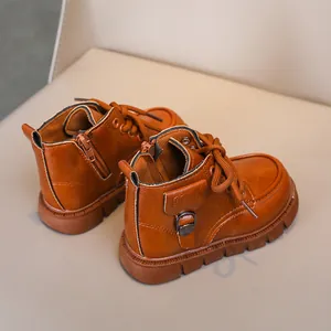 Detailed view of children's brown leather boots with anti-slip rubber soles and zipper