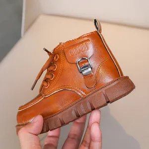 Close-up of brown children's leather boots with buckle detail and anti-slip thick rubber sole
