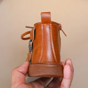Detail view of brown leather children boots with side zipper and durable non-slip sole