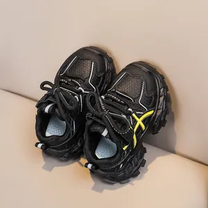 Detail view of children's sports shoes with breathable black mesh and yellow stripe accents