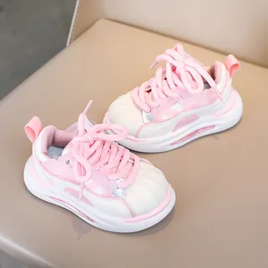 Close-up of pink and beige kids sneakers with soft soles and shell-toe texture