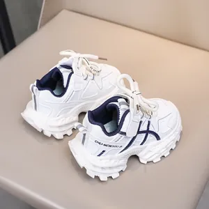 Detail of children's white sports shoe with navy accents and hook-and-loop strap closure