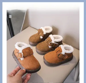 Close-up of brown suede kids winter boots with warm faux shearling lining and metal buckle