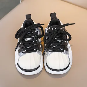 Detailed top view of kids sneakers featuring a classic shell toe and black woven laces