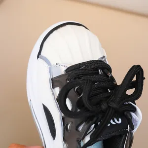 Close-up of kids casual sneakers with rubber shell toe and black thick rope laces