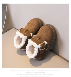 Close-up of brown suede winter boot with white faux fur lining and gold buckle detail