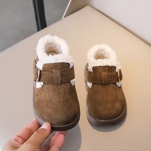 Close-up of brown suede toddler boots with thick white faux fur lining and buckle detail
