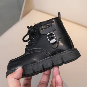 Détail de bottines en cuir noir pour enfants avec bride à boucle et semelle antidérapante