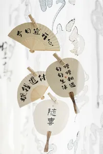 Detail of artistic paper fans with Chinese calligraphy hanging on clips for decoration