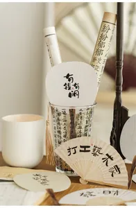 Macro detail of traditional Chinese style mini paper fans with calligraphy and gold tassels