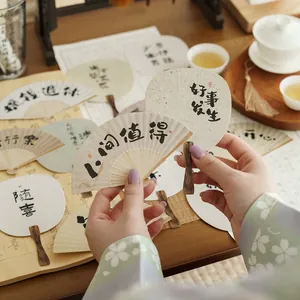 Traditional Chinese folding fans and round fans with calligraphy in a tea room setting